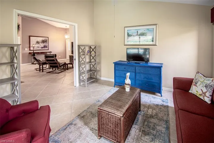 Living room with tile patterned floors and lofted ceiling
