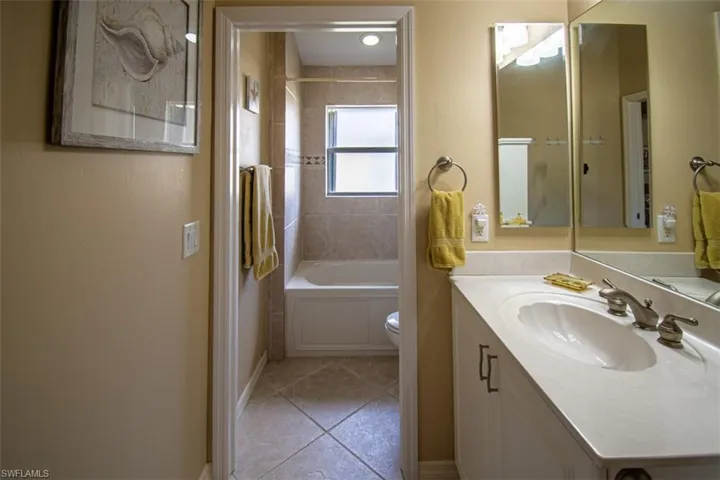 Full bathroom with vanity, shower / bath combination, and light tile patterned flooring