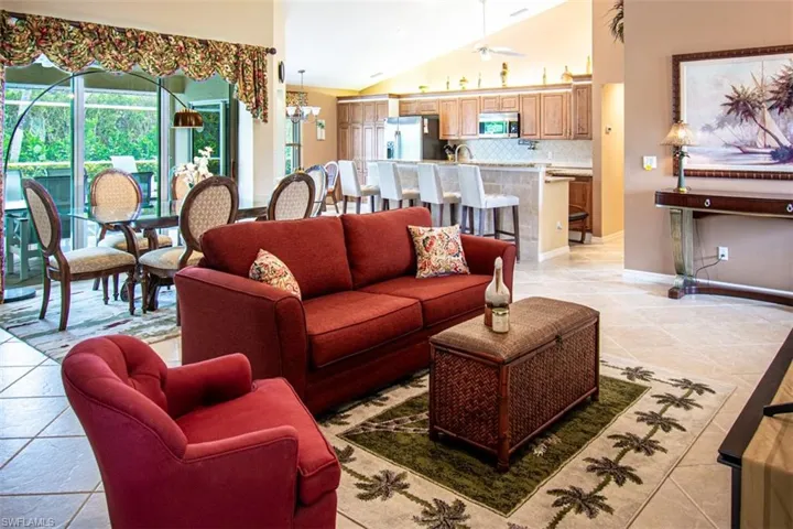 Living area with light tile patterned floors, a chandelier, and high vaulted ceiling
