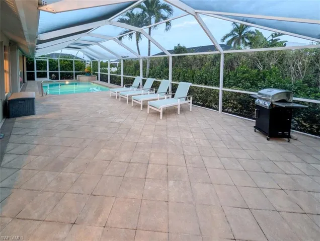 View of patio / terrace with a lanai, a grill, a sunroom, and an outdoor pool