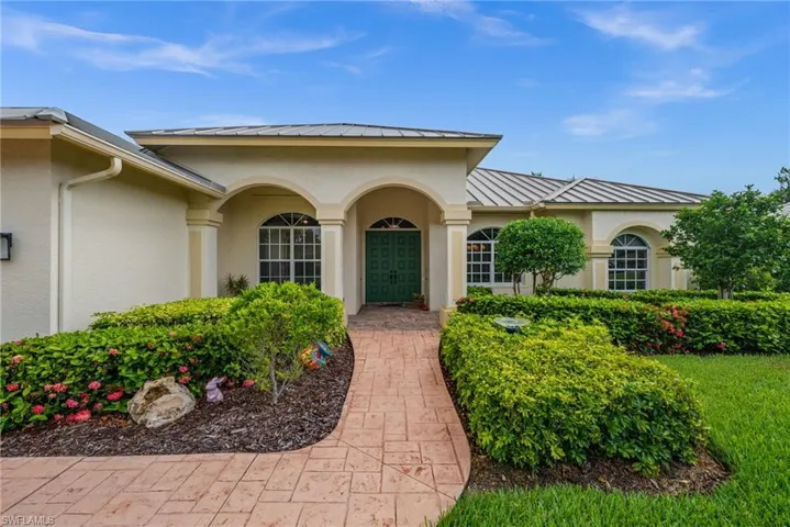 Welcoming front with double doors and arched windows.