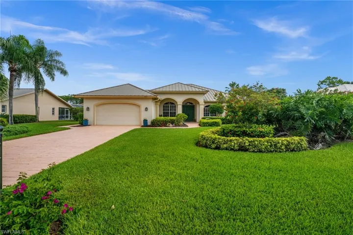 Outstanding curb appeal welcomes you home with a long paver driveway, manicured landscaping and covered entry.