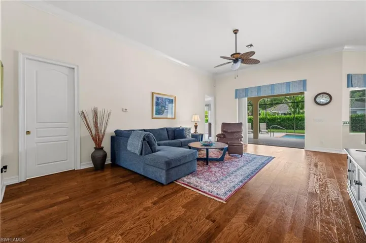 The light-filled living room features soaring ceilings, beautiful wood flooring, and an open, airy design that creates a warm and welcoming space for everyday living and entertaining.