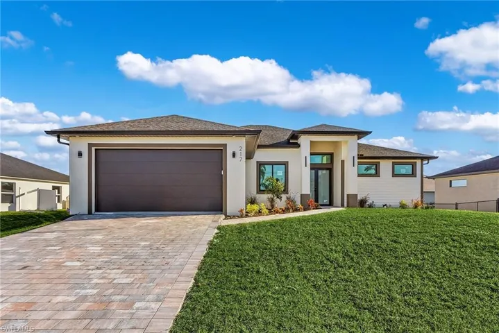 Prairie-style house featuring a garage and a front yard