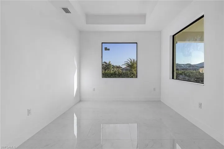 Unfurnished room with a tray ceiling