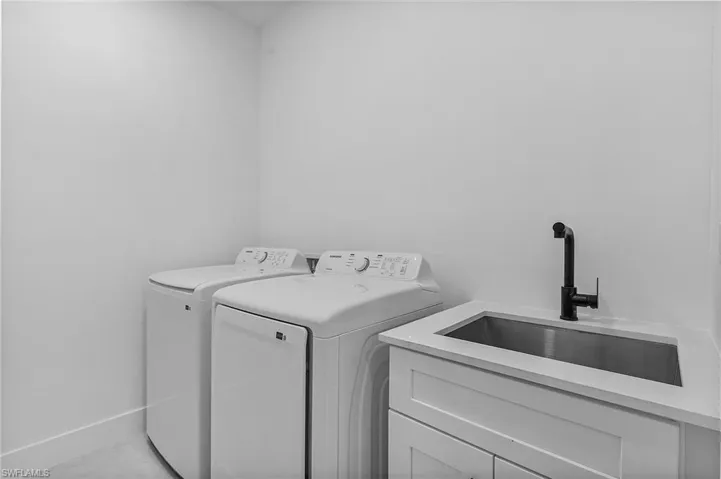 Washroom featuring sink, cabinets, and independent washer and dryer