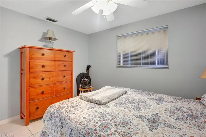 Tiled bedroom with a textured ceiling and ceiling fan