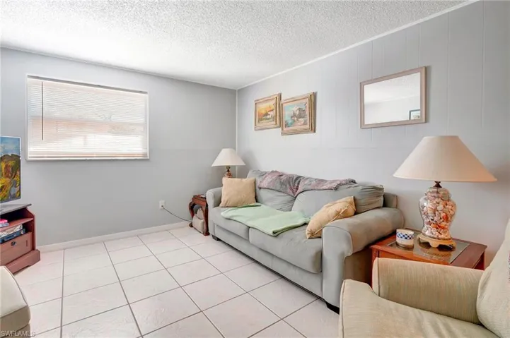 Tiled living room featuring a textured ceiling