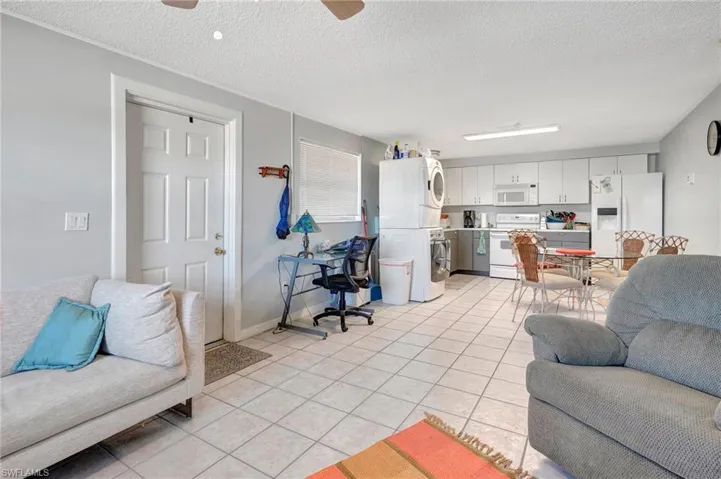 Tiled living room featuring ceiling fan and a textured ceiling
