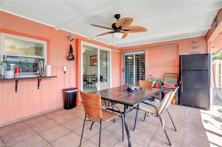 Tiled dining room with beamed ceiling and ceiling fan