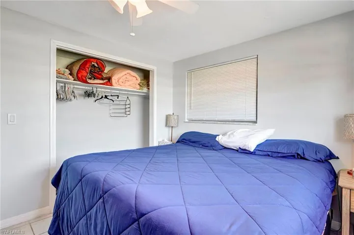Tiled bedroom with a closet and ceiling fan