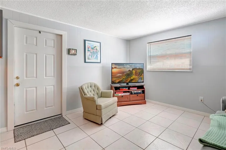 Living area featuring a textured ceiling and light tile floors
