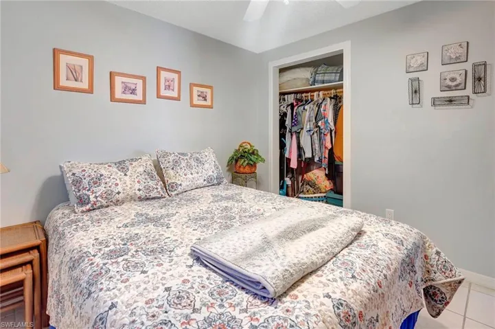 Tiled bedroom with ceiling fan and a closet
