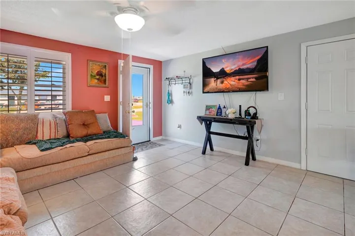Living room featuring ceiling fan and light tile floors