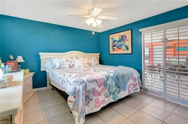Tiled bedroom with a textured ceiling and ceiling fan