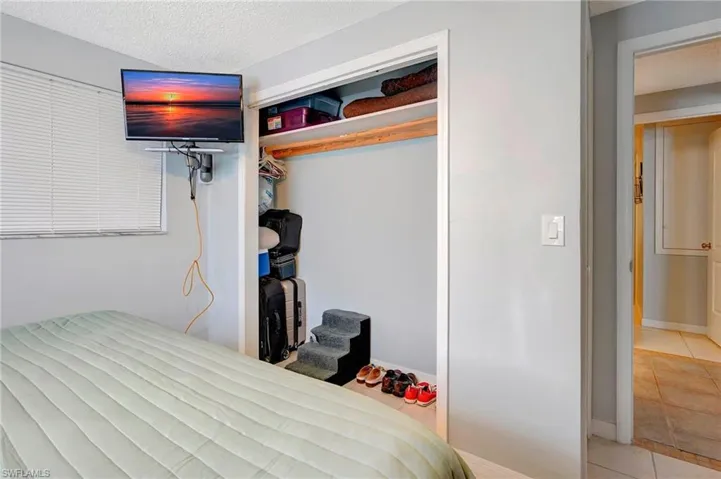 Tiled bedroom with a closet and a textured ceiling