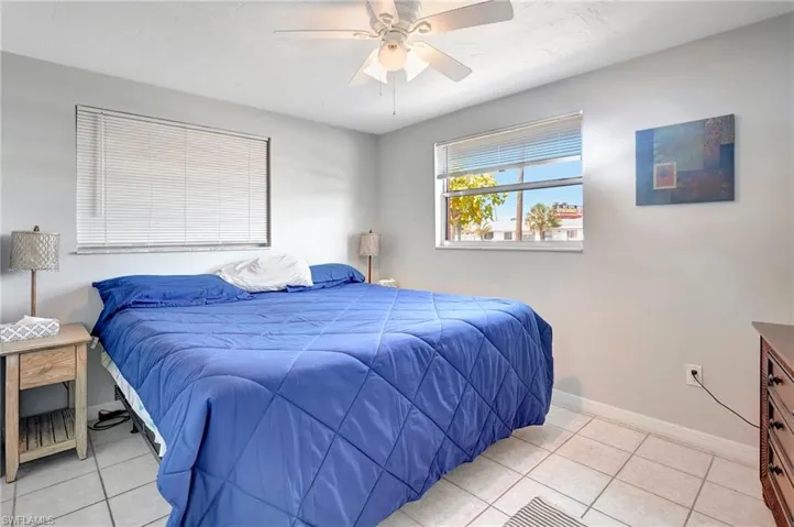 Tiled bedroom featuring ceiling fan