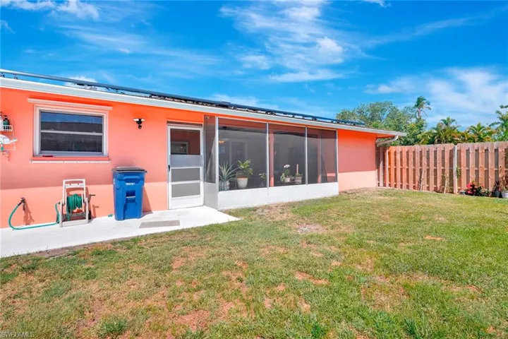 Rear view of property with a sunroom and a lawn