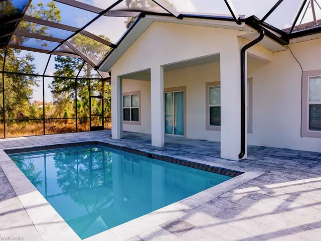 The property features a screened-in pool area with a covered patio, providing an ideal space for outdoor enjoyment