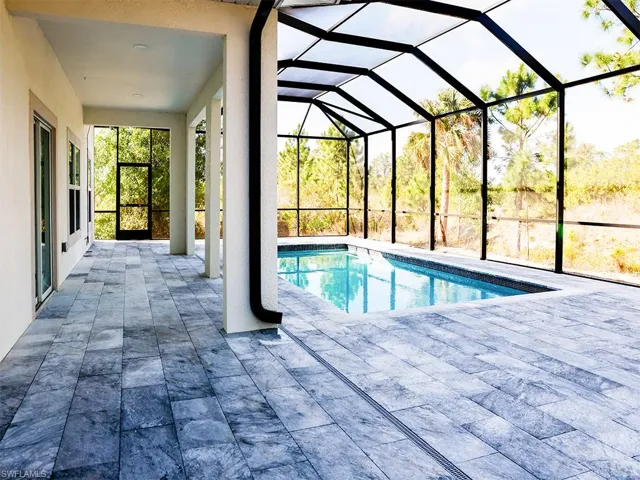 The property features a screened-in pool area with a covered patio