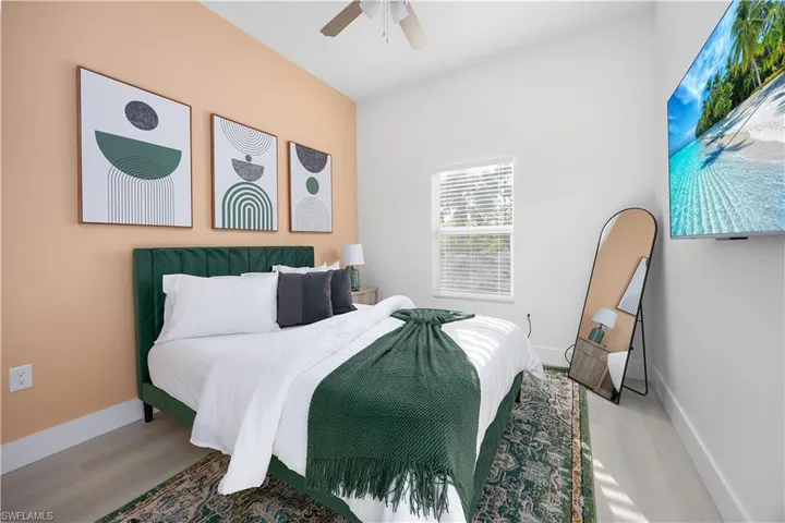 Bedroom featuring light-colored flooring, a window with blinds, and a ceiling fan