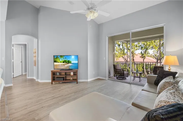 Living area featuring light-toned flooring and access to a screened balcony