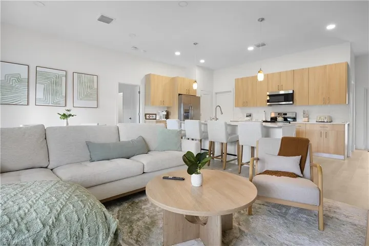 Open-concept living area and kitchen with recessed lighting