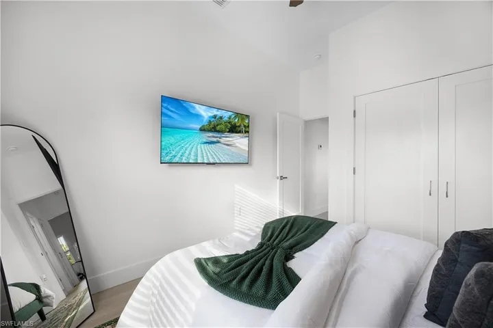 This room features white walls, light-colored flooring, and white closet doors with silver handles