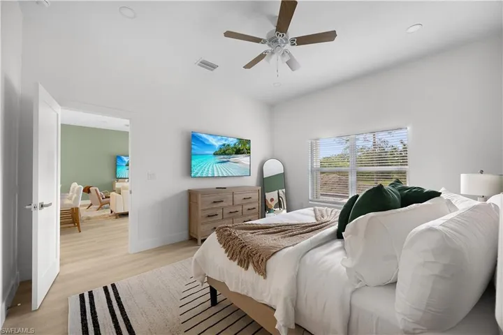 This room features light-colored flooring, white walls, and a ceiling fan