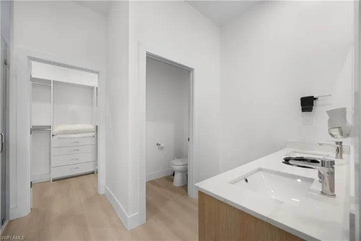 Bathroom featuring a double vanity with an integrated sink, polished chrome faucets, and wood-look cabinetry