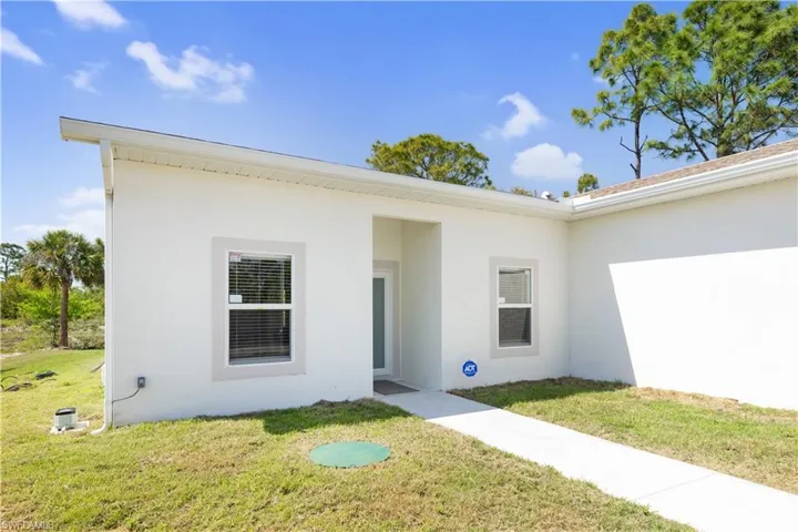 The property features a white exterior with white trim around the windows and an angled roofline