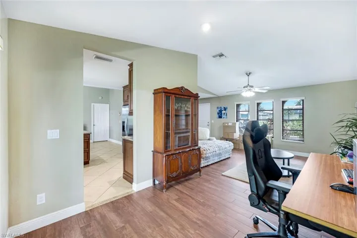 Office space featuring a ceiling fan, light wood-style floors, vaulted ceiling, and recessed lighting
