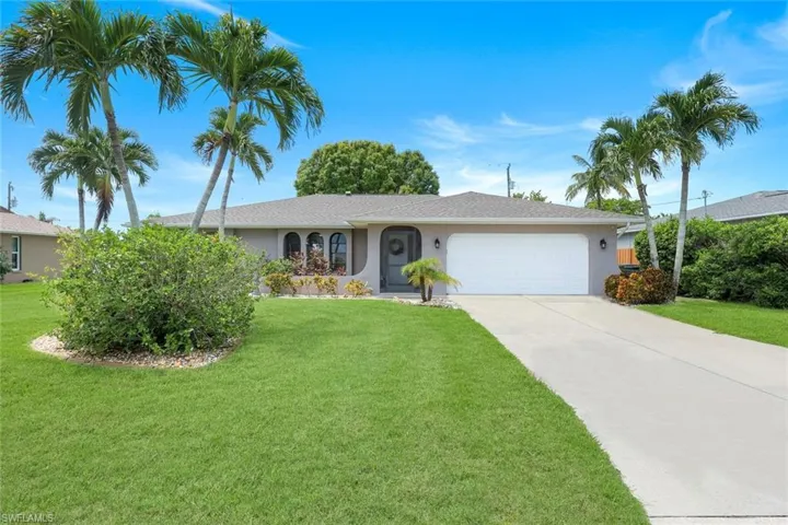 Ranch-style house with an attached garage, stucco siding, driveway, and a front yard