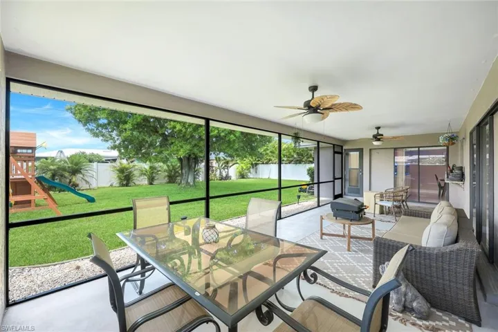 Sunroom / solarium with a water view, a ceiling fan, and outdoor dining area