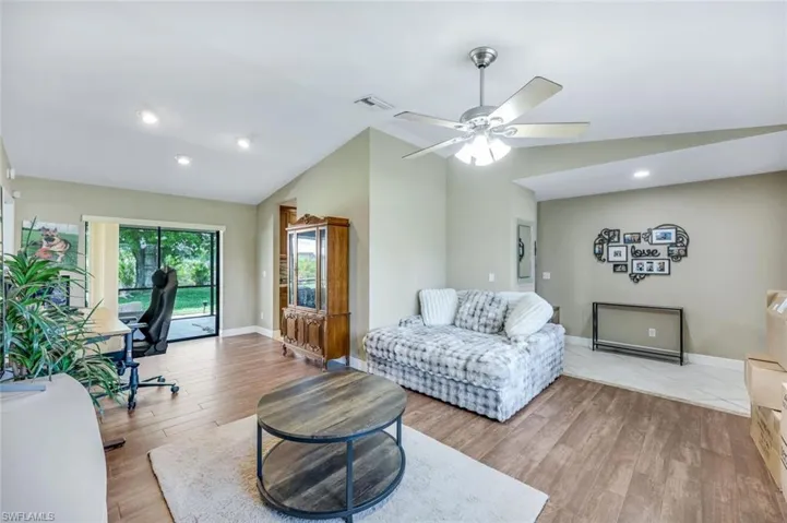 Living area with vaulted ceiling, light wood finished floors, a ceiling fan, and recessed lighting