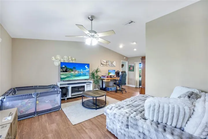 Living room featuring wood finished floors, ceiling fan, lofted ceiling, an office area, and recessed lighting