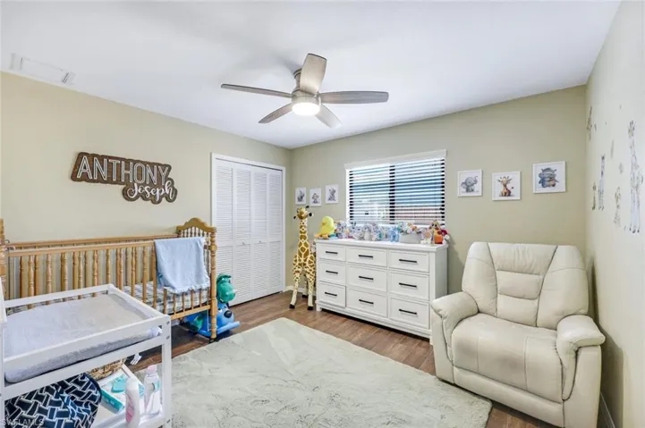 Bedroom featuring dark wood-type flooring, a closet, and a ceiling fan