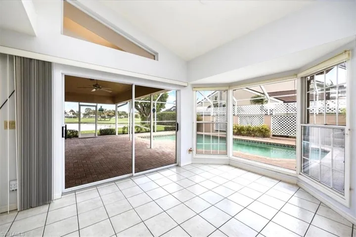 Unfurnished sunroom with lofted ceiling, healthy amount of natural light, and ceiling fan