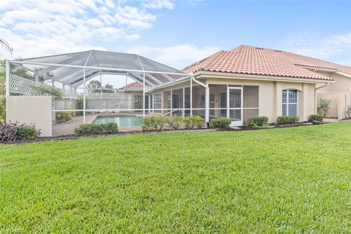 Rear view of property featuring an outdoor pool, a tile roof, stucco siding, and a lanai