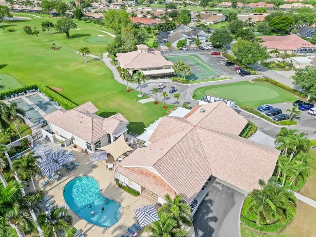 Aerial view of residential area with a golf course and a pool area