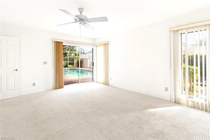 Spare room featuring carpet floors, a ceiling fan, and baseboards