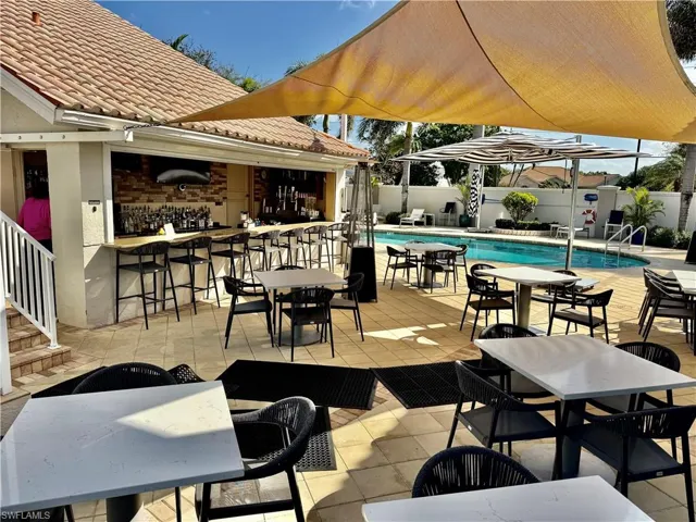 View of patio with outdoor dry bar, outdoor dining space, a fenced in pool, and fence