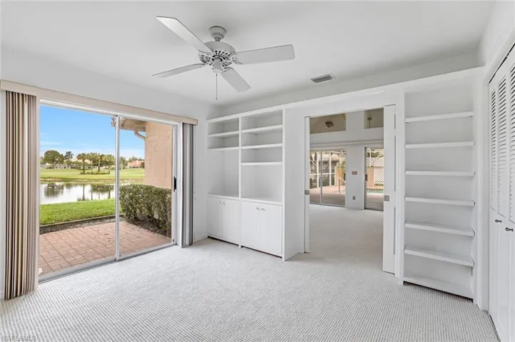 Unfurnished bedroom featuring carpet flooring, access to exterior, a water view, and multiple windows