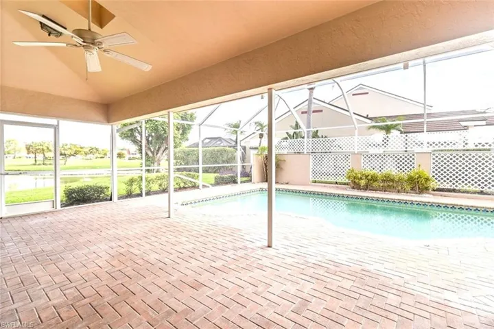 Swimming pool with a ceiling fan, a patio area, and glass enclosure