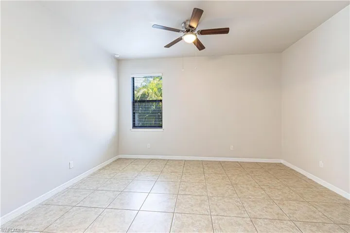 Empty room featuring a ceiling fan and light tile patterned floors