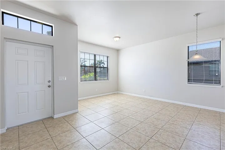 Entryway with light tile patterned flooring and baseboards