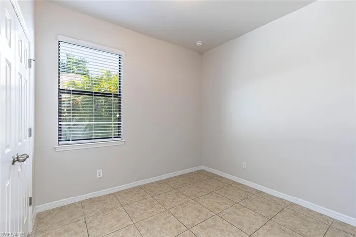 Empty room featuring baseboards and light tile patterned floors