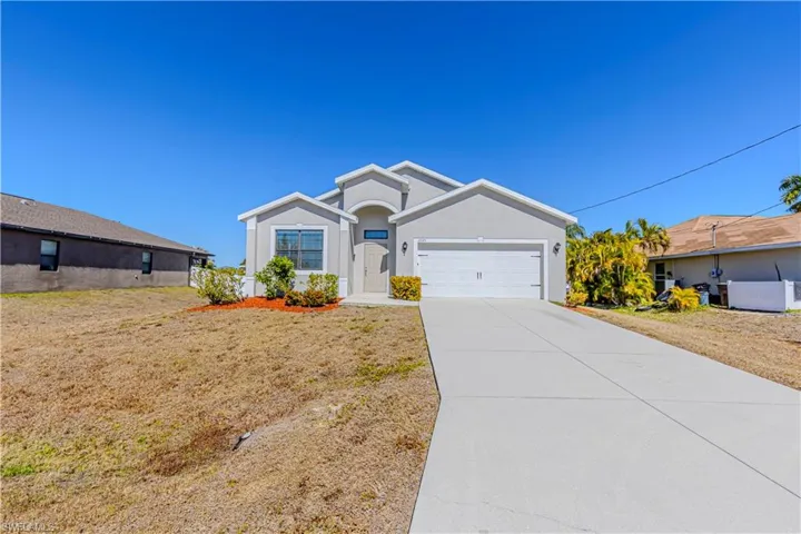 Ranch-style home with a garage, concrete driveway, and stucco siding
