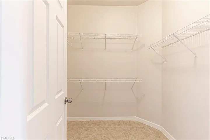 Walk in closet with light tile patterned floors