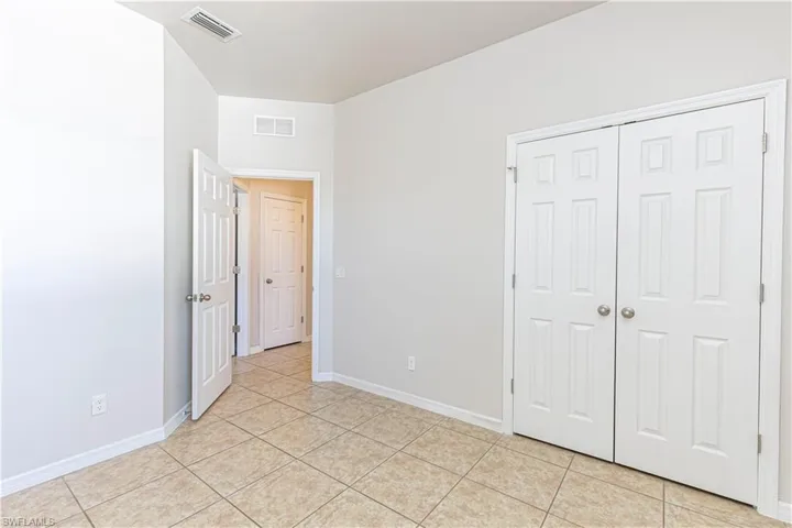 Unfurnished bedroom featuring a closet and light tile patterned floors